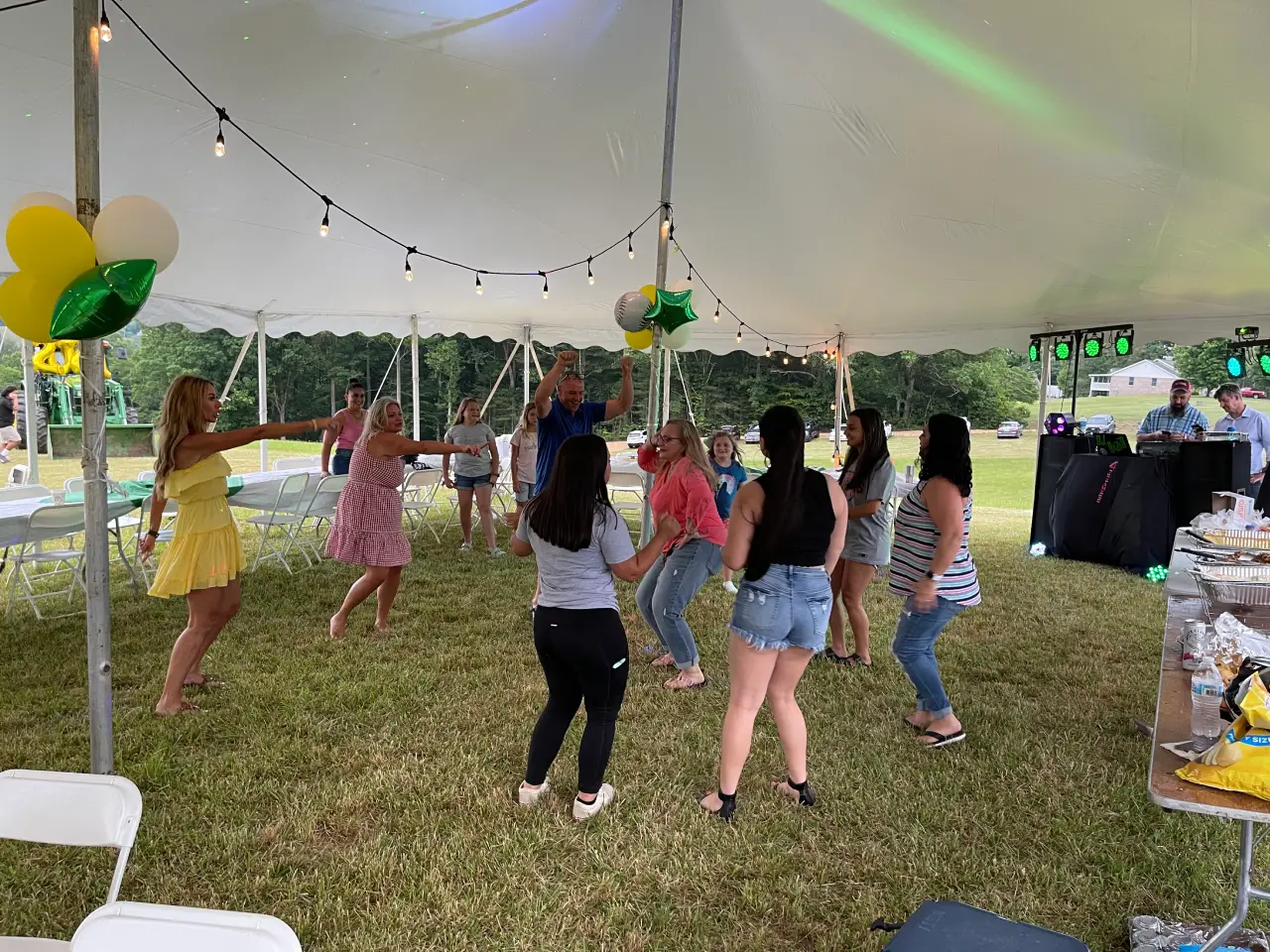 A group of people dancing under an awning.