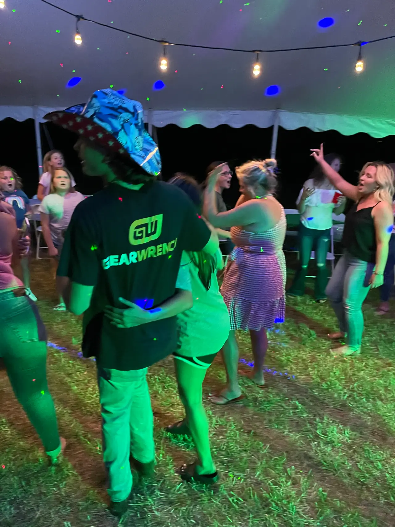 A group of people dancing in the grass.