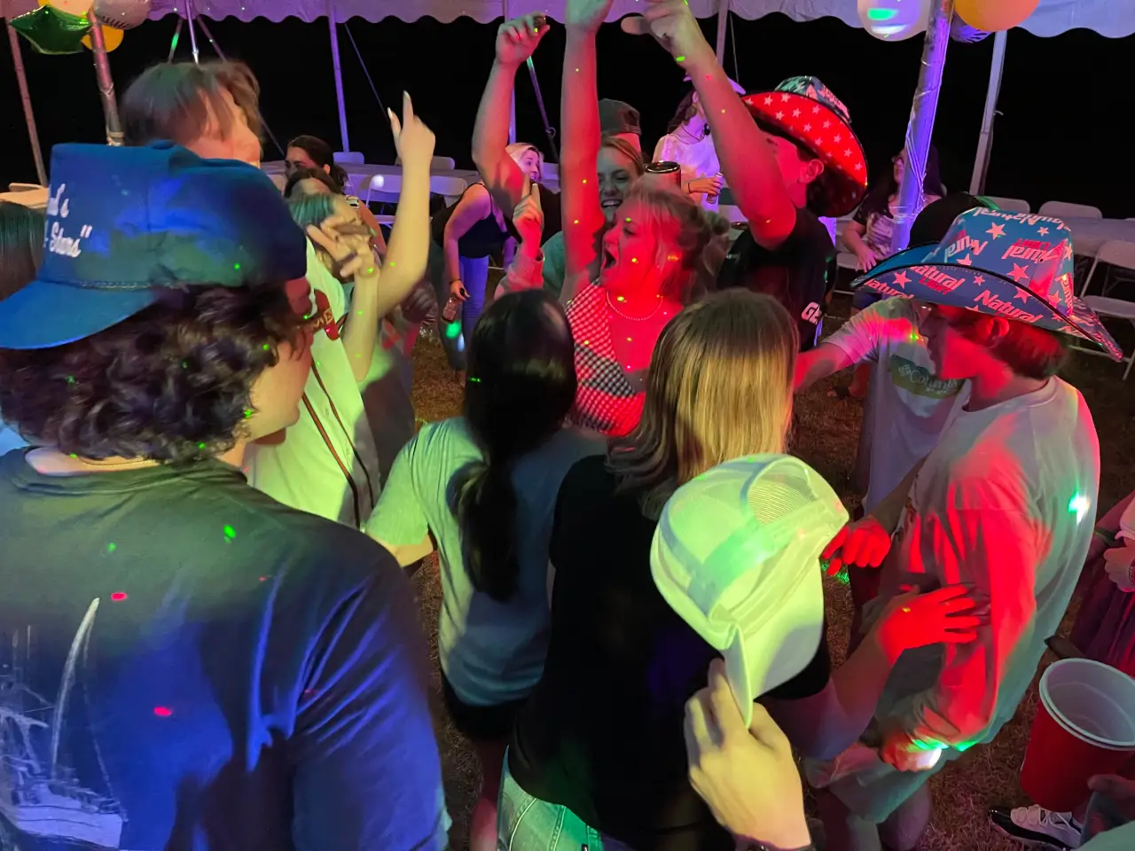 A group of people dancing in the dark.