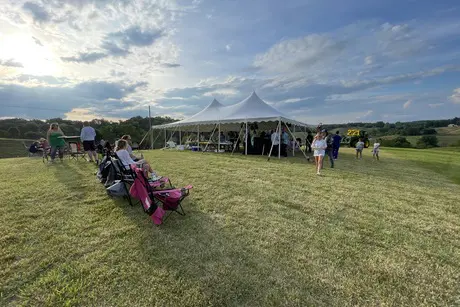 A group of people standing around an open field.