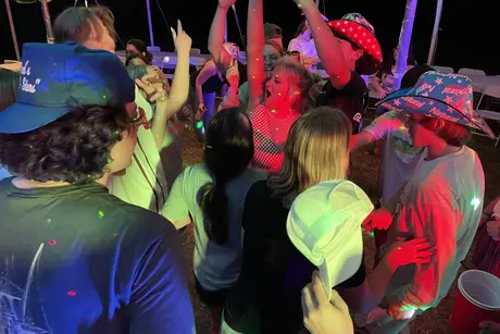A crowd of people standing around in the dark.