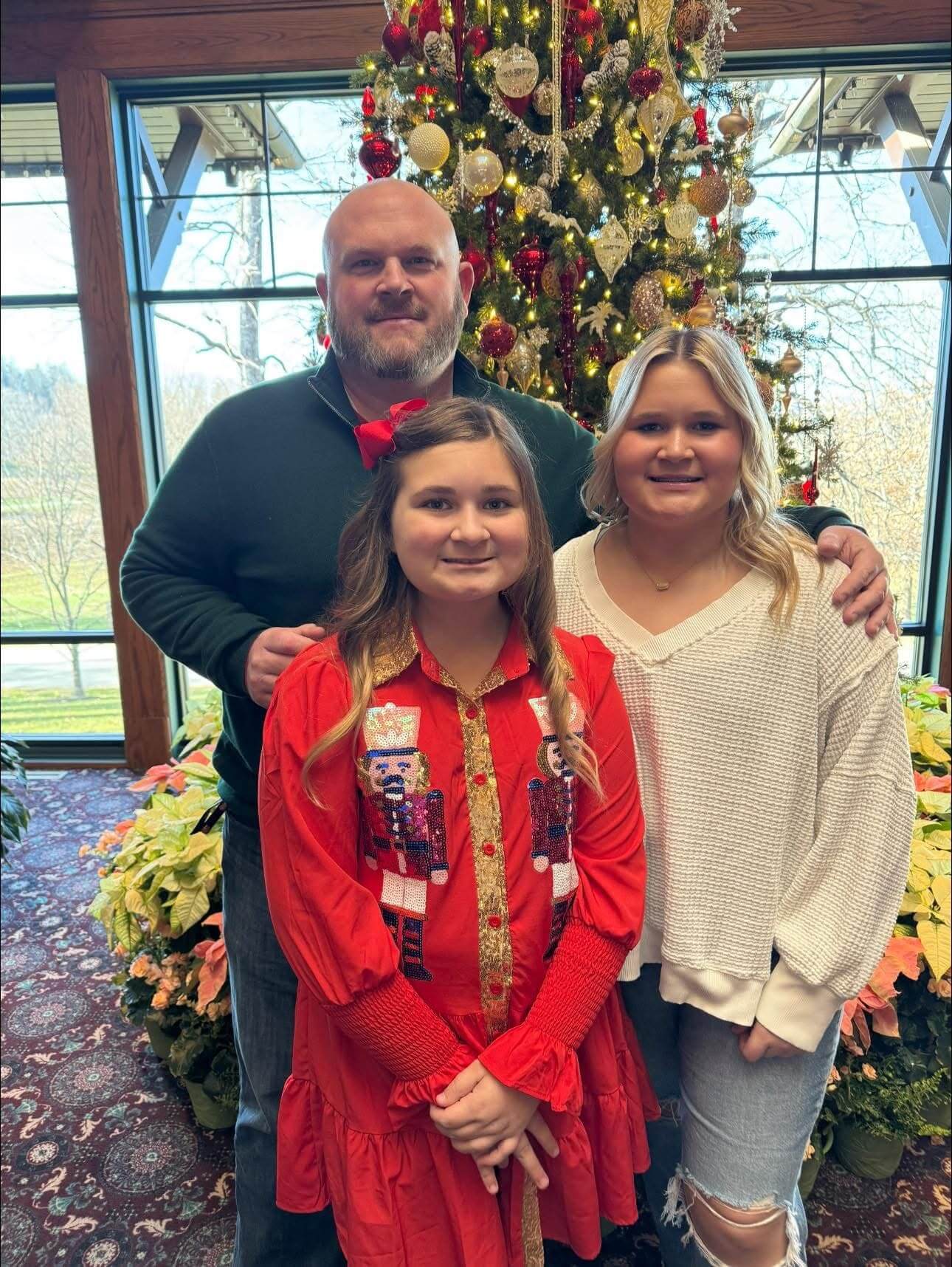 A family posing for a picture in front of a christmas tree.
